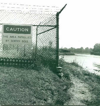 Edge of the misile base at lagoon edge, with fence and sign. Jackson Park. Nancy Hays